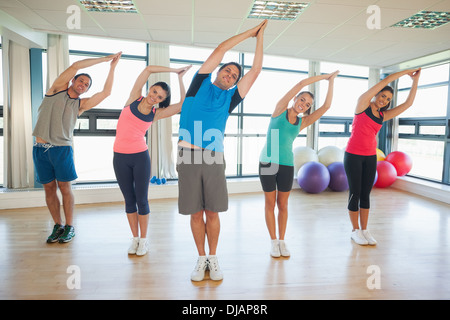 Fitness-Klasse und Lehrer stehen in Namaste position Stockfoto