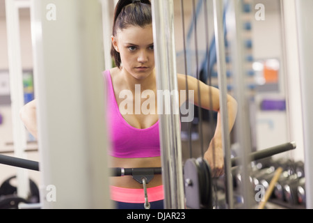 Entschlossenen Frau, die Übungen im Fitnessraum auf Lat-Maschine Stockfoto