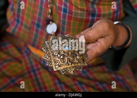 Bhutan, Nobding, Frau halten traditionelle alte Silber Korma-Brosche in der hand Stockfoto