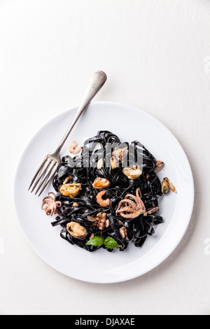 Schwarze Pasta mit Meeresfrüchten auf weißen Teller Stockfoto