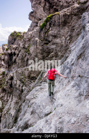 Weibliche Wanderer zu Fuß entlang der festen Kabeltrasse von Jubilaeumssteig, einen Abschnitt über den Wilder-Kaiser-Steig-Wanderweg Stockfoto