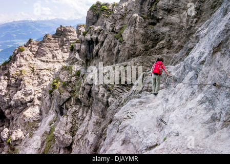 Weibliche Wanderer zu Fuß entlang der festen Kabeltrasse von Jubilaeumssteig, einen Abschnitt über den Wilder-Kaiser-Steig-Wanderweg Stockfoto