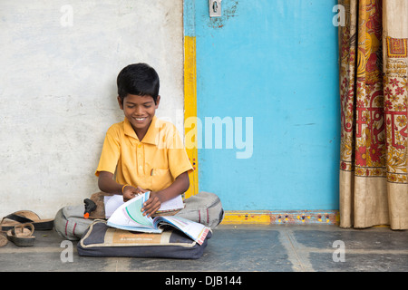 Indische Junge Schule Arbeit außerhalb seiner ländlichen Heimat Indianerdorf. Andhra Pradesh, Indien Stockfoto