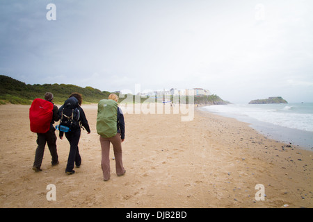Drei Erwachsene zu Fuß in Richtung Tenby auf Küstenpfad Pembrokeshire Wales Stockfoto