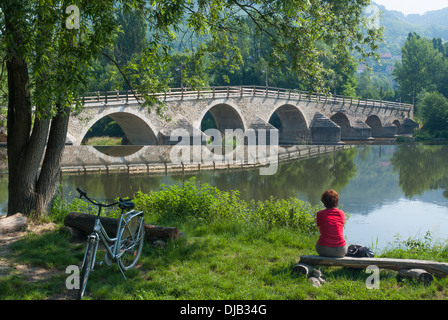 Restaurierte Brücke über der Saale, Radfahrer sitzen am Ufer Flusses, Jena-Burgau, Jena, Thüringen, Deutschland Stockfoto