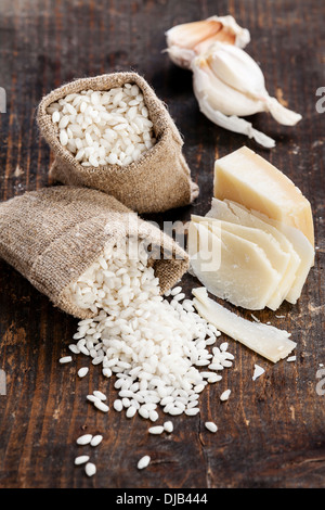 Roher Reis in Jute-Tasche mit Zutaten für risotto Stockfoto