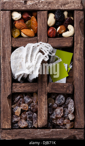 Teebeutel, Nüssen, Rosinen, braunem Zucker in Holzkiste Stockfoto