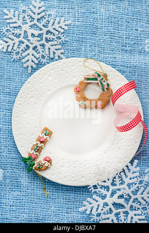 Weißen Teller mit Weihnachtsdekoration auf blauem Hintergrund, Overhead, Exemplar Stockfoto