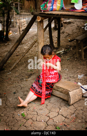 Ein Kind tun Stickerei in einem Stamm Dorf von Luang Prabang, Laos. Stockfoto