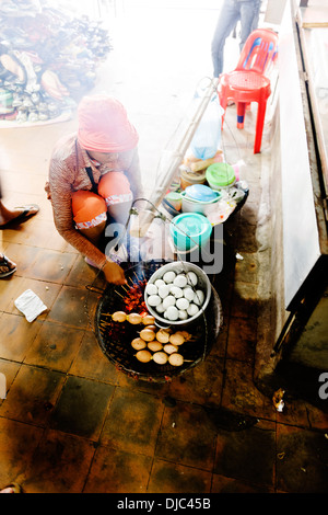 Eine Frau Grillen Enteneier in Battambang Central Market, Kambodscha. Stockfoto