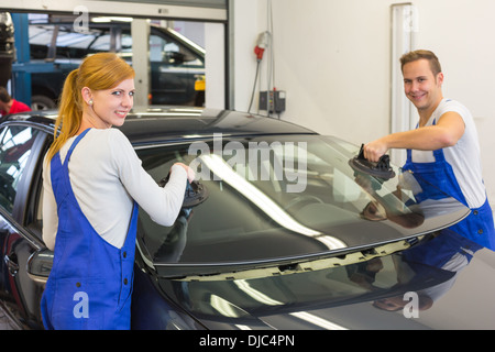 Zwei Glaser ersetzen nach Steinschlag Frontscheibe oder Frontscheibe auf einem Auto in Werkstatt Stockfoto