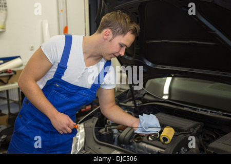 Mechaniker in Garage oder Werkstatt prüfen motor Ölstand am Auto Stockfoto