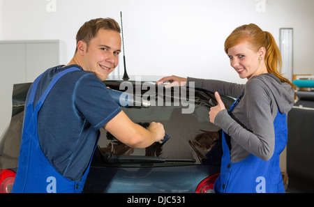 Auto-Wrapper Tönung einer Fahrzeugscheibe mit einem getönte Folie oder Film mit Heißluftpistole und Rakel Stockfoto