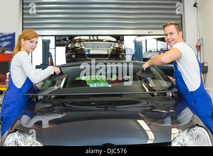 Zwei Glaser ersetzen nach Steinschlag Frontscheibe oder Frontscheibe auf einem Auto in Werkstatt Stockfoto