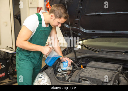 Mechaniker Minen Kühlmittel oder Kühlflüssigkeit im Motor eines Autos Stockfoto