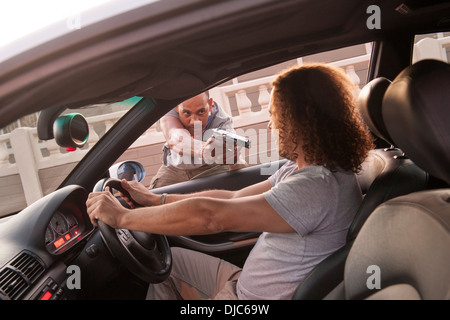 Mann immer Carjacked mit vorgehaltener Waffe. Stockfoto