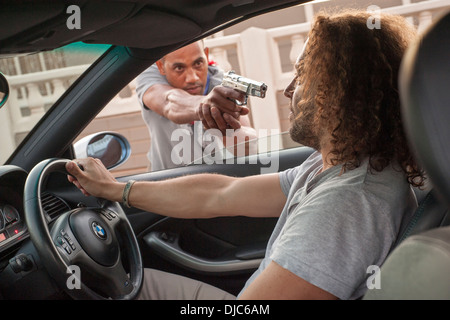 Mann immer Carjacked mit vorgehaltener Waffe. Stockfoto