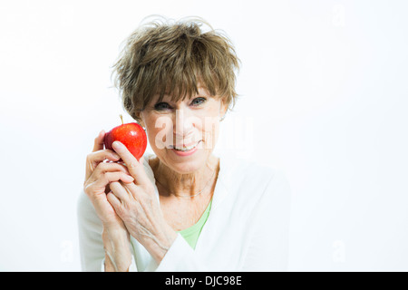 Reife Frau mit roter Apfel Stockfoto