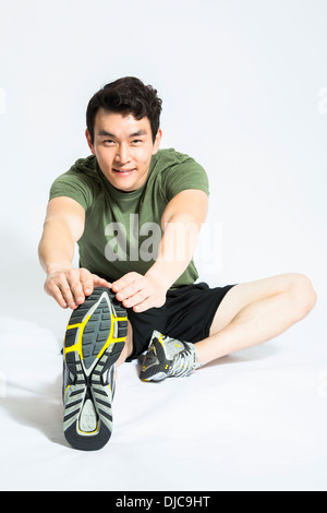 Sportliche jungen männlichen Streckung der Beine und Füße Stockfoto