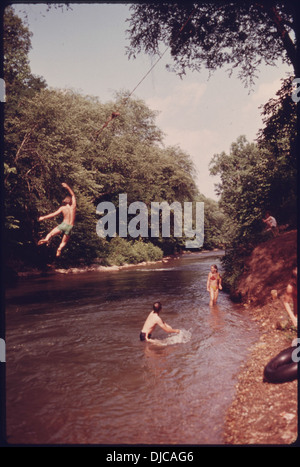 Dieses Bild zeigt Kinder, die auf einer Seilschaukel am Big Rock spielen, einem beliebten lokalen Erholungsort am Chattahoochee River. Der Fluss ist bekannt für seine landschaftliche Schönheit und seine Freizeitmöglichkeiten. Stockfoto