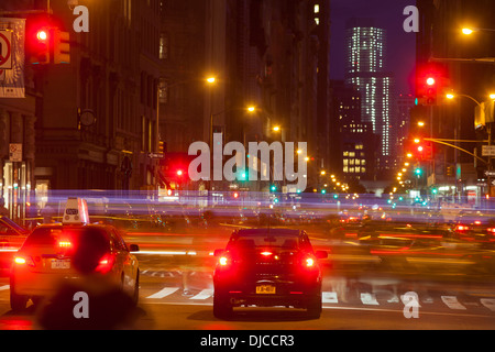 Eine Unschärfe von Autos und Menschen auf der Fifth Avenue in New York City in der Nacht. Bewegungsunschärfe. Langzeitbelichtung Stockfoto