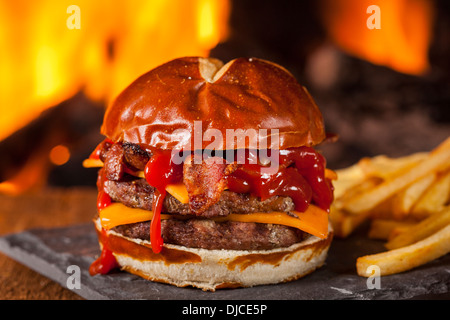 Ungesunde selbstgemachten Barbecue Bacon Cheeseburger mit Pommes frites Stockfoto