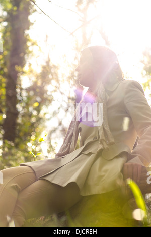 Frau sitzt vor der Sonne Stockfoto