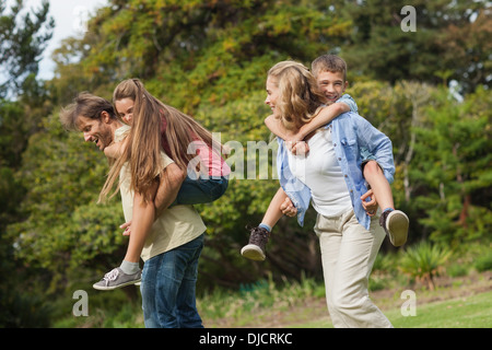 Eltern ihre Kinder auf ihrem Rücken zu tragen Stockfoto