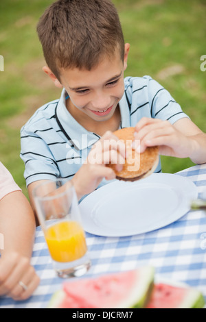 Kleiner Junge mit seiner Familie Burger Essen Stockfoto