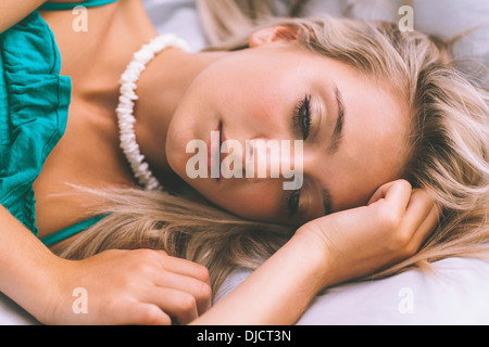 Wunderschöne nachdenklich Blondine posiert Bett liegend Stockfoto