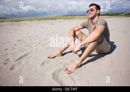 Attraktives Lächeln Mann sitzen und die Sonne genießen Stockfoto