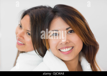 Zwei glückliche Schwestern tragen Bademäntel Stockfoto