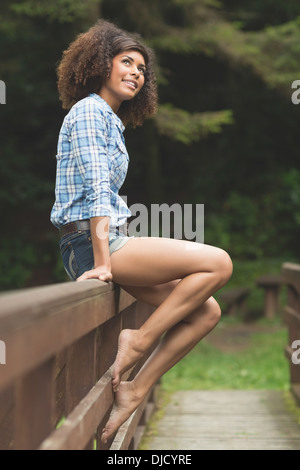 Wunderschöne nachdenklich Brünette sitzt auf Brücke Stockfoto