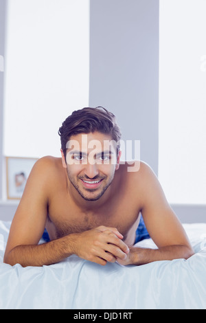 Hübscher junger Mann auf seinem Bett liegend Stockfoto