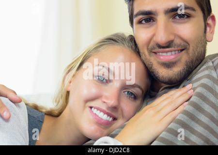 Nettes junges Paar kuscheln auf couch Stockfoto