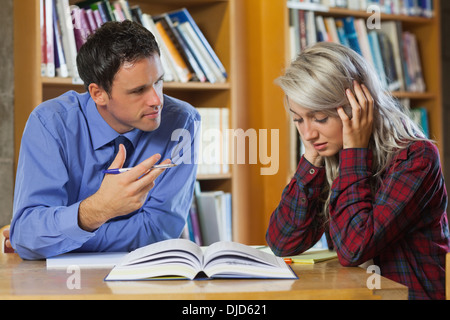 Dozent erklärt etwas frustriert blonde Studentin Stockfoto