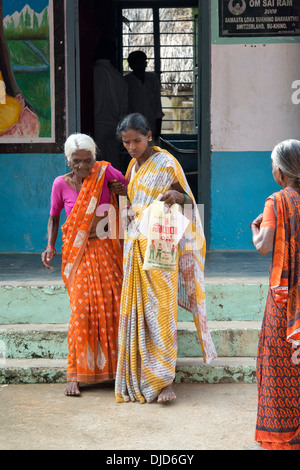 Alte indische Frau geholfen werden, aus Sri Sathya Sai Baba mobile aufsuchende Klinik. Andhra Pradesh, Indien Stockfoto