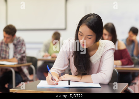 Konzentrierte sich asiatische Studentin Notizen in der Klasse Stockfoto