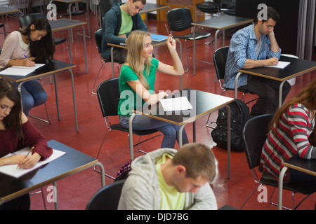 Blonde Studentin hob ihre Hand in der Klasse Stockfoto