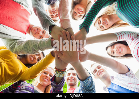 Gruppe von lächelnden Studenten setzen Hände in einem Kreis auf dem campus Stockfoto