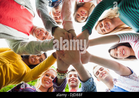 Gruppe von glücklichen Studenten setzen Hände in einem Kreis auf dem campus Stockfoto