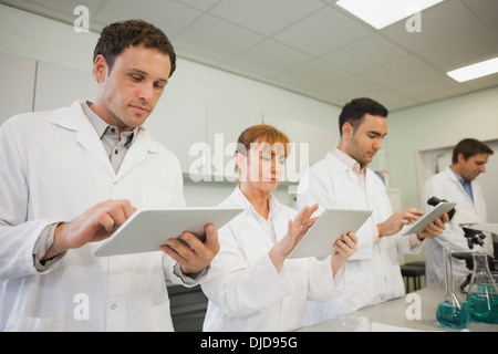 Reihe von Wissenschaftlern mit ihren Tabletten Stockfoto