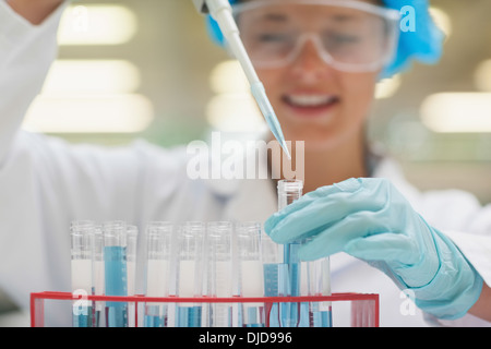 Student mit Pipette hält Reagenzglas lächelnd Stockfoto
