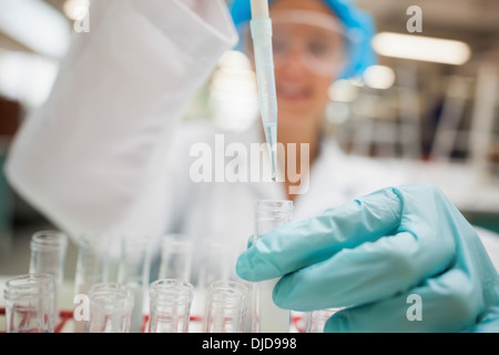 Student mit Pipette hält Reagenzglas Stockfoto