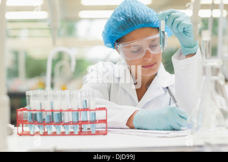 Student mit Reagenzglas und Notizen Stockfoto