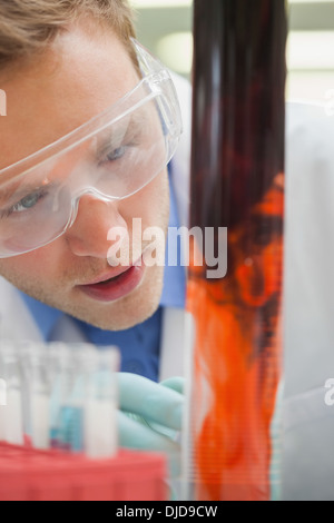 Begeistert Schüler beobachten purpurrote Flüssigkeit mischen mit rot Stockfoto