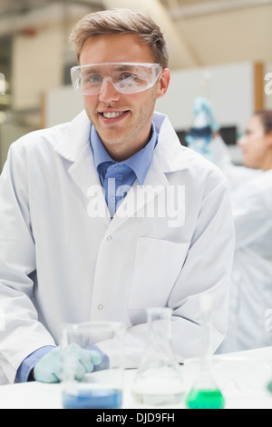 Hübsche Studentin in Laborkittel Blick in die Kamera Lächeln Stockfoto