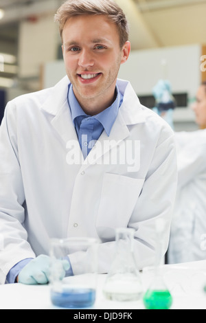 Fröhliche gut aussehend Student im Laborkittel Blick in die Kamera Stockfoto
