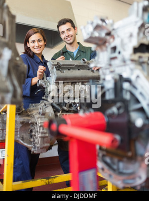 Glücklich Auszubildende und Ausbilder, die Reparatur eines Motors Stockfoto