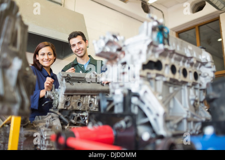 Lächelnd, Auszubildende und Ausbilder, die Reparatur eines Motors Stockfoto